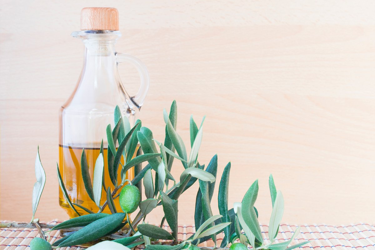Extra virgin olive oil bottle with olive branch and olive | Oliveo Escapes